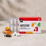 Cápsulas de ArtiZynt con cúrcuma y pimienta negra sobre un fondo neutro